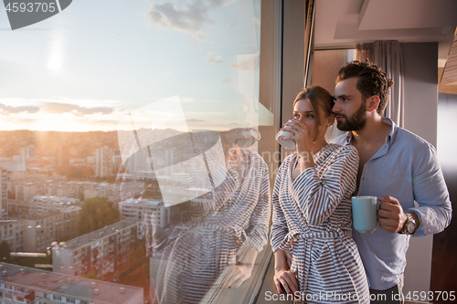 Image of young couple enjoying evening coffee by the window