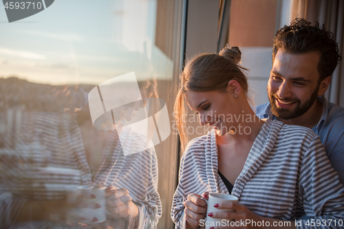 Image of young couple enjoying evening coffee by the window