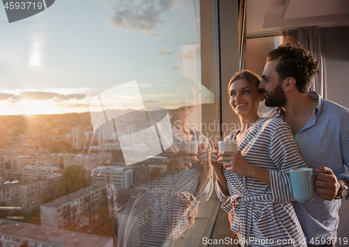 Image of young couple enjoying evening coffee by the window