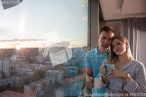 Image of young couple enjoying evening coffee by the window