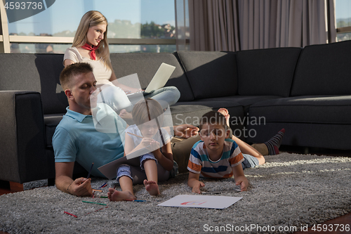 Image of young couple spending time with kids at home