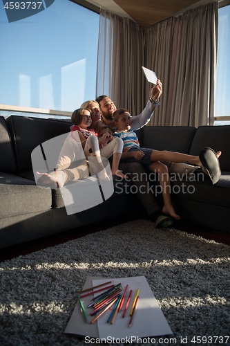 Image of happy young couple spending time with kids at home