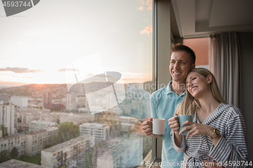 Image of young couple enjoying evening coffee by the window