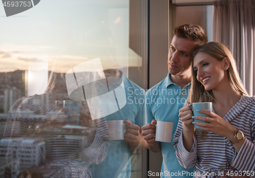 Image of young couple enjoying evening coffee by the window