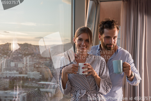 Image of young couple enjoying evening coffee by the window