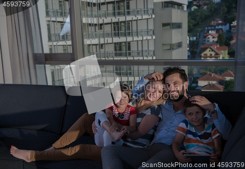 Image of happy young couple spending time with kids at home