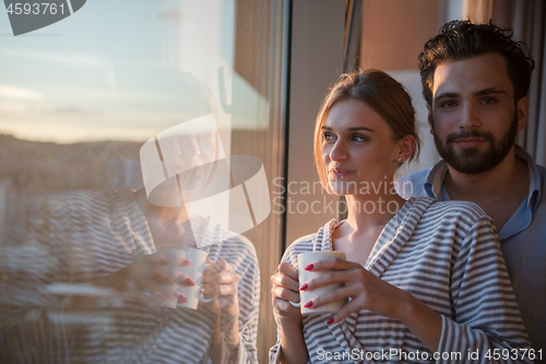 Image of young couple enjoying evening coffee by the window