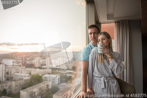 Image of young couple enjoying evening coffee by the window