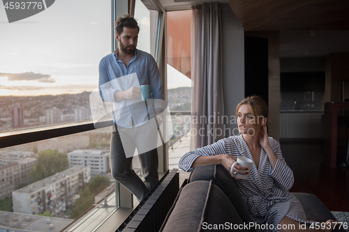 Image of young couple enjoying evening coffee by the window