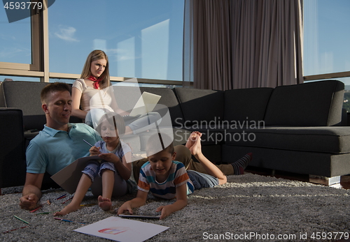 Image of young couple spending time with kids at home