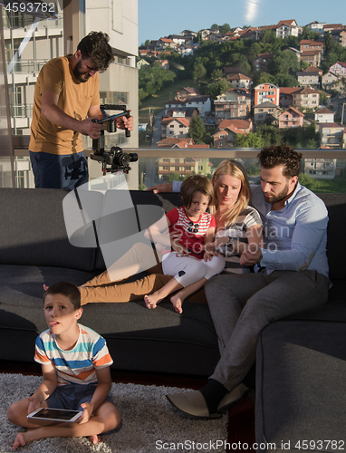 Image of happy young couple spending time with kids at home