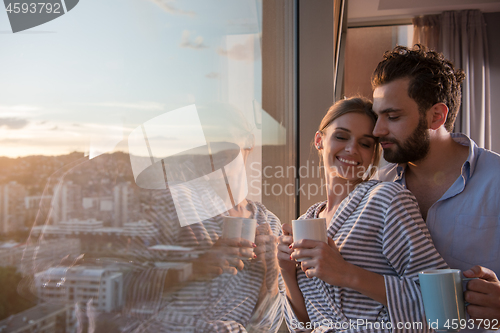 Image of young couple enjoying evening coffee by the window