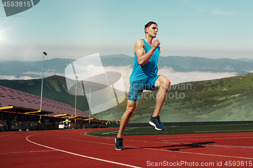 Image of man running in the track. Fit male fitness runner jogging in stadium