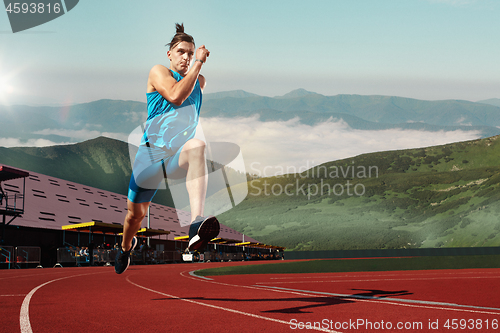 Image of man running in the track. Fit male fitness runner jogging in stadium