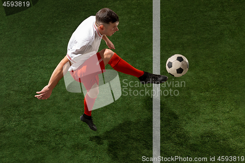 Image of Football player tackling ball over green grass background