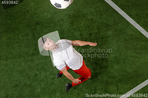 Image of Football player tackling ball over green grass background