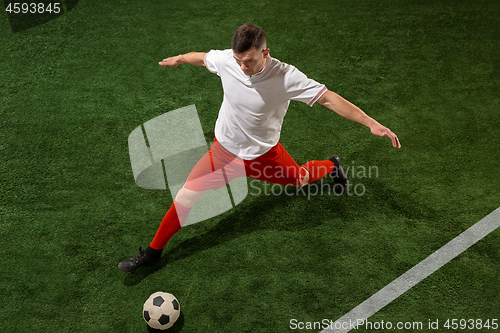 Image of Football player tackling ball over green grass background