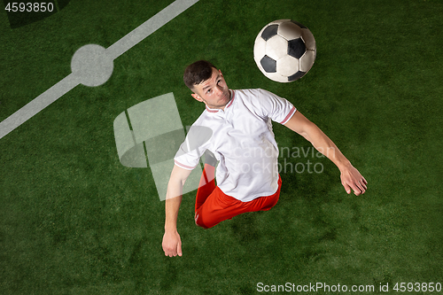 Image of Football player tackling ball over green grass background