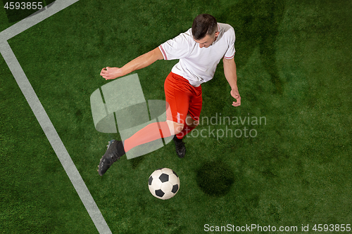 Image of Football player tackling ball over green grass background