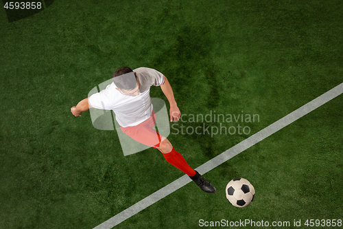 Image of Football player tackling ball over green grass background