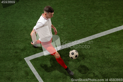 Image of Football player tackling ball over green grass background