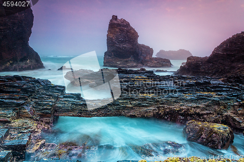 Image of Natural bridge over tidal waters along craggy coastline