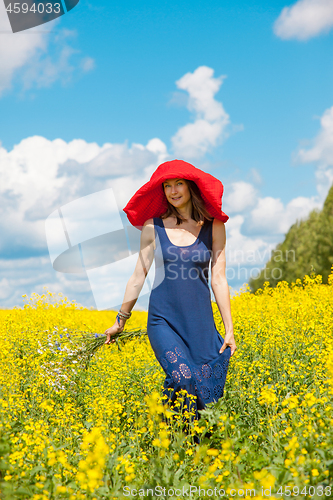 Image of  woman in a red hat and a bouquet of wild flowers