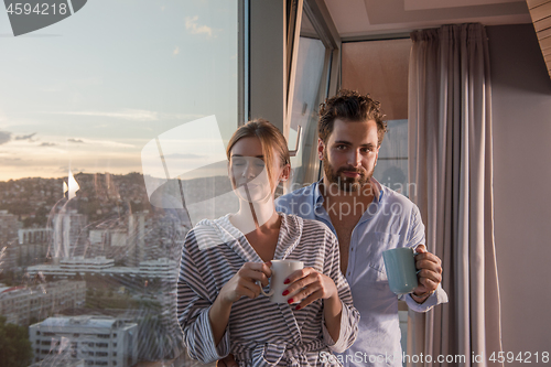 Image of young couple enjoying evening coffee by the window