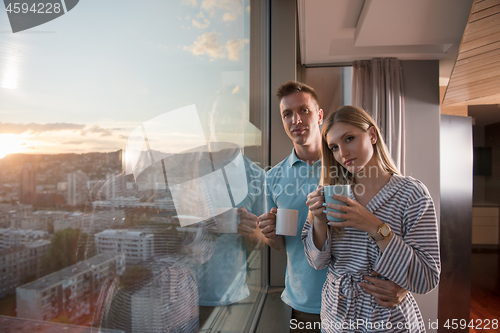 Image of young couple enjoying evening coffee by the window