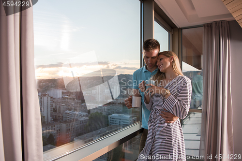 Image of young couple enjoying evening coffee by the window