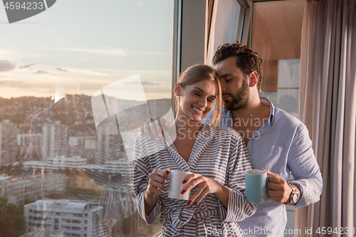 Image of young couple enjoying evening coffee by the window