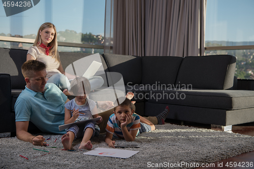 Image of young couple spending time with kids at home