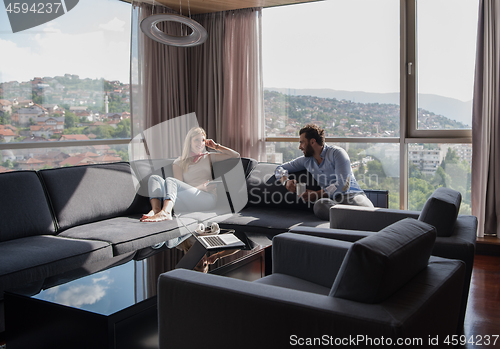 Image of couple relaxing at  home using tablet computer