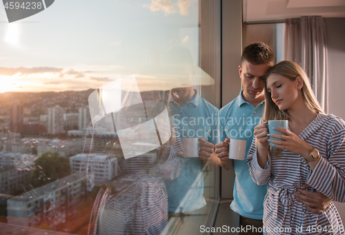 Image of young couple enjoying evening coffee by the window