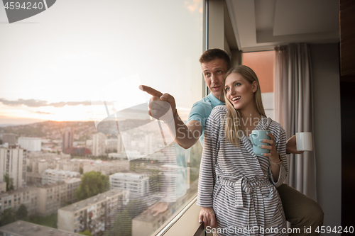 Image of young couple enjoying evening coffee by the window