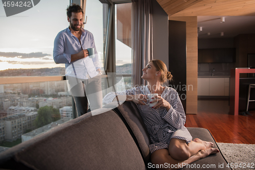 Image of young couple enjoying evening coffee by the window