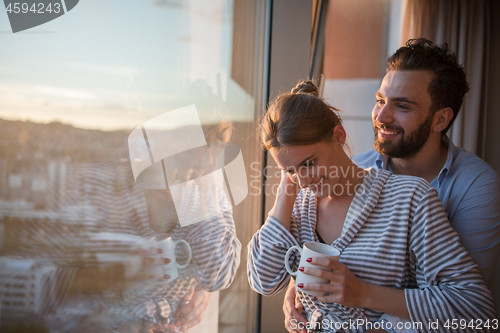 Image of young couple enjoying evening coffee by the window