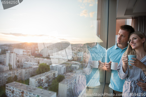 Image of young couple enjoying evening coffee by the window