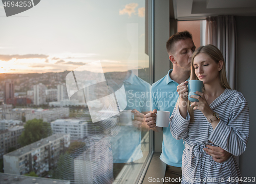 Image of young couple enjoying evening coffee by the window