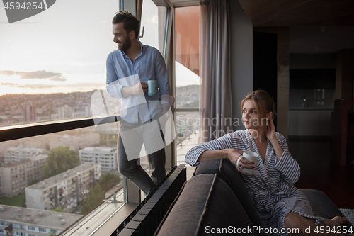 Image of young couple enjoying evening coffee by the window