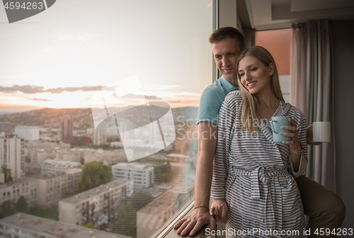 Image of young couple enjoying evening coffee by the window