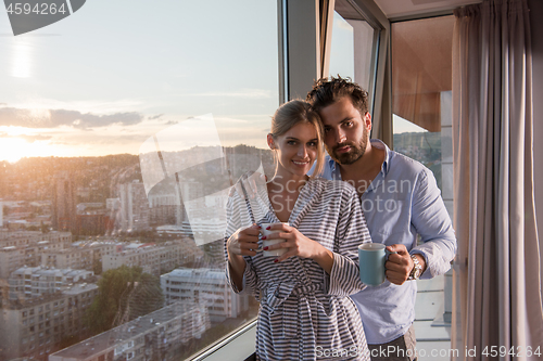 Image of young couple enjoying evening coffee by the window