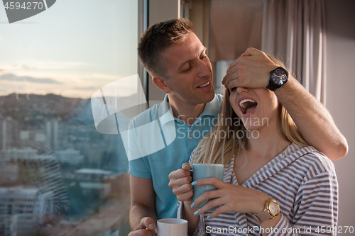 Image of young couple enjoying evening coffee by the window