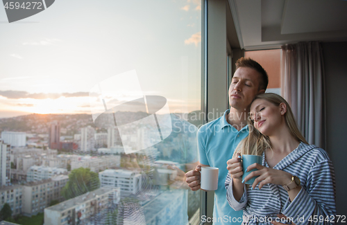 Image of young couple enjoying evening coffee by the window