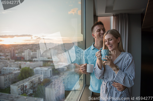 Image of young couple enjoying evening coffee by the window