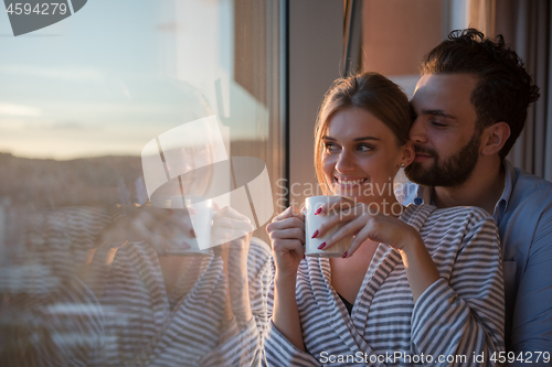 Image of young couple enjoying evening coffee by the window