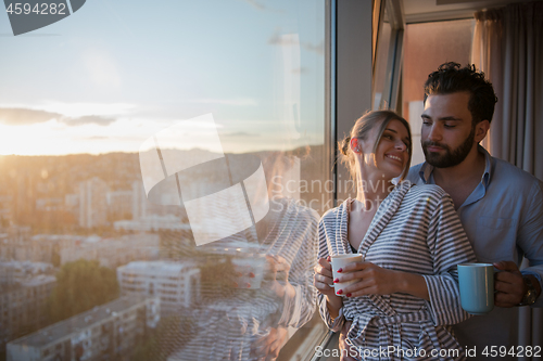 Image of young couple enjoying evening coffee by the window