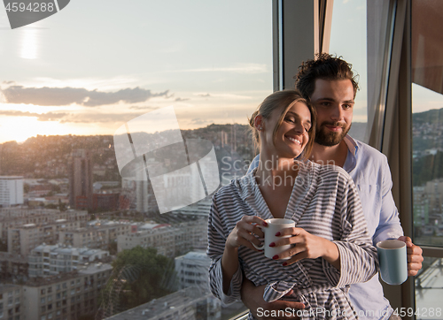 Image of young couple enjoying evening coffee by the window