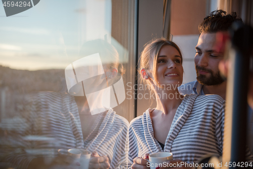 Image of young couple enjoying evening coffee by the window