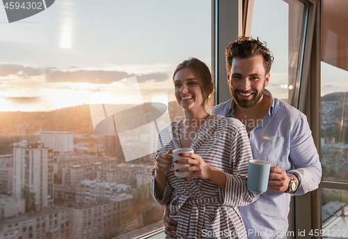 Image of young couple enjoying evening coffee by the window